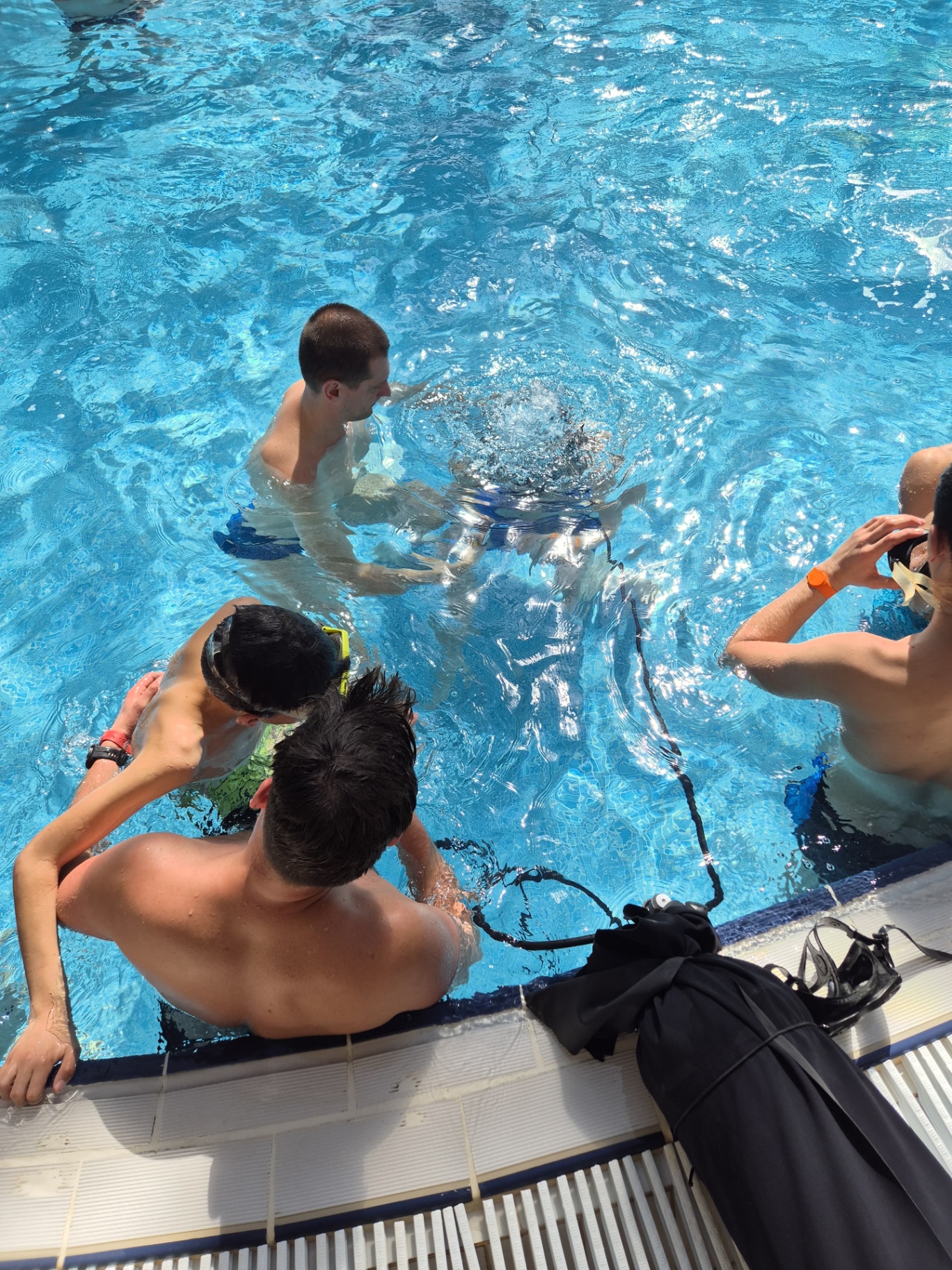Inițiere în scufundări într-o piscină, cu instructori alături de participanți