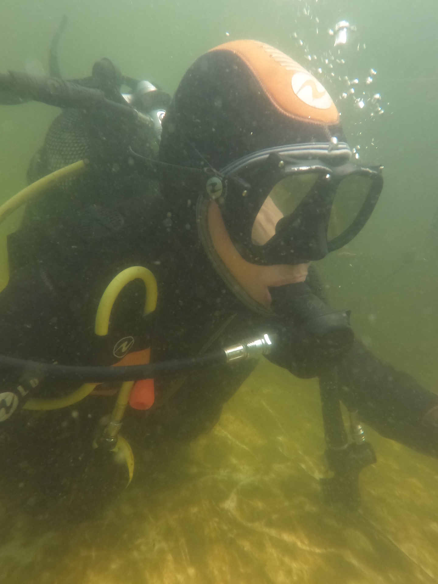 Scafandru cu mască și regulator, fotografiat sub apă într-un lac